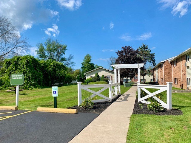 a white fence and a sidewalk in front of a house