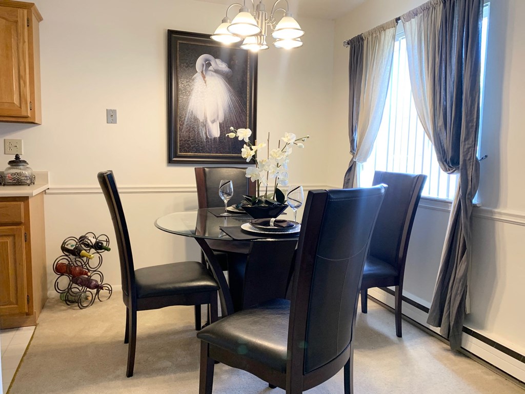 a dining room with a table and chairs and a window