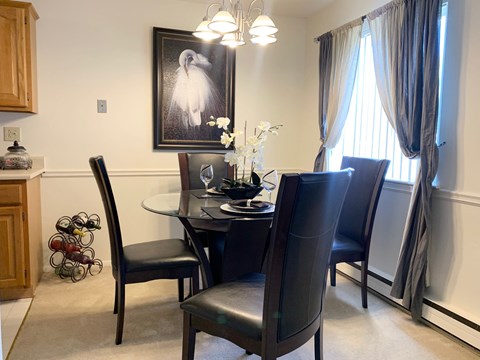Dining area with glass table and upholstered chairs at Chili Heights Apartments, Rochester, NY