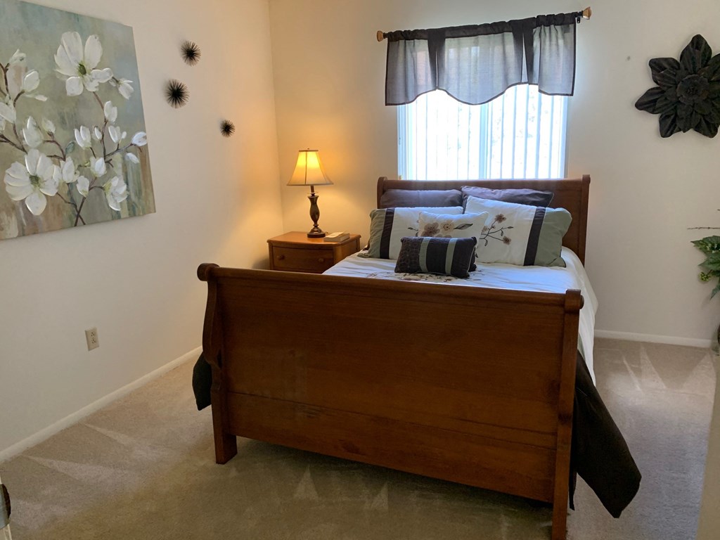 a bedroom with a wooden bed and a window