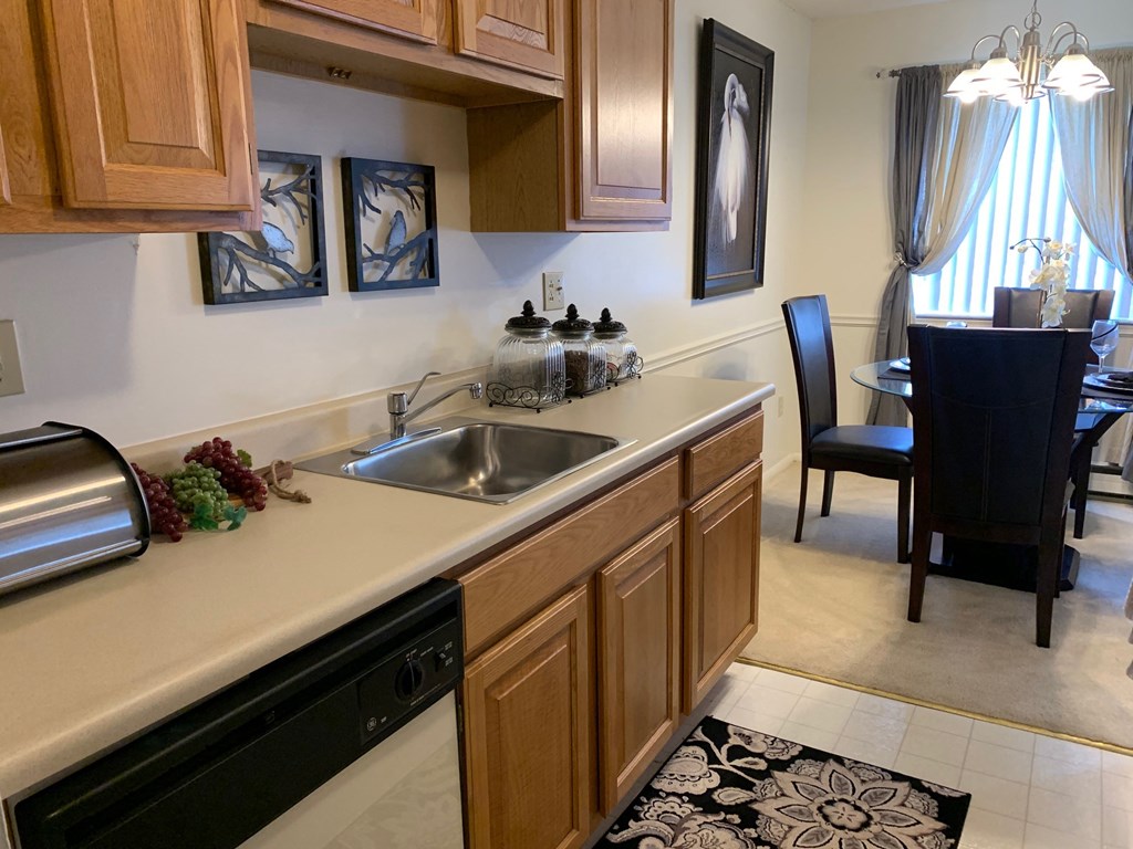 a kitchen with a sink and a dining room with a table