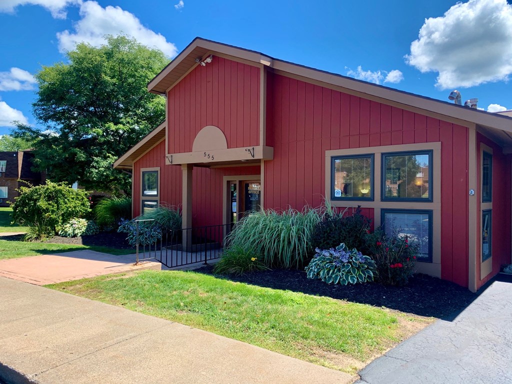 a red house with a sidewalk in front of it