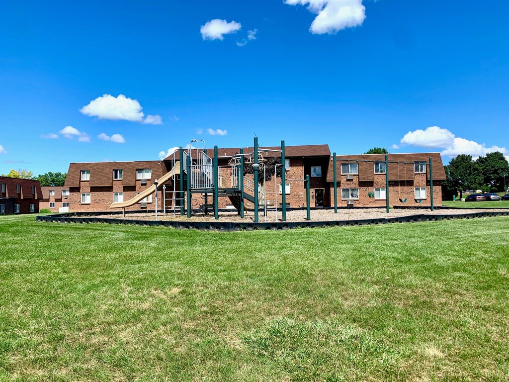 a large playground in front of a brick building