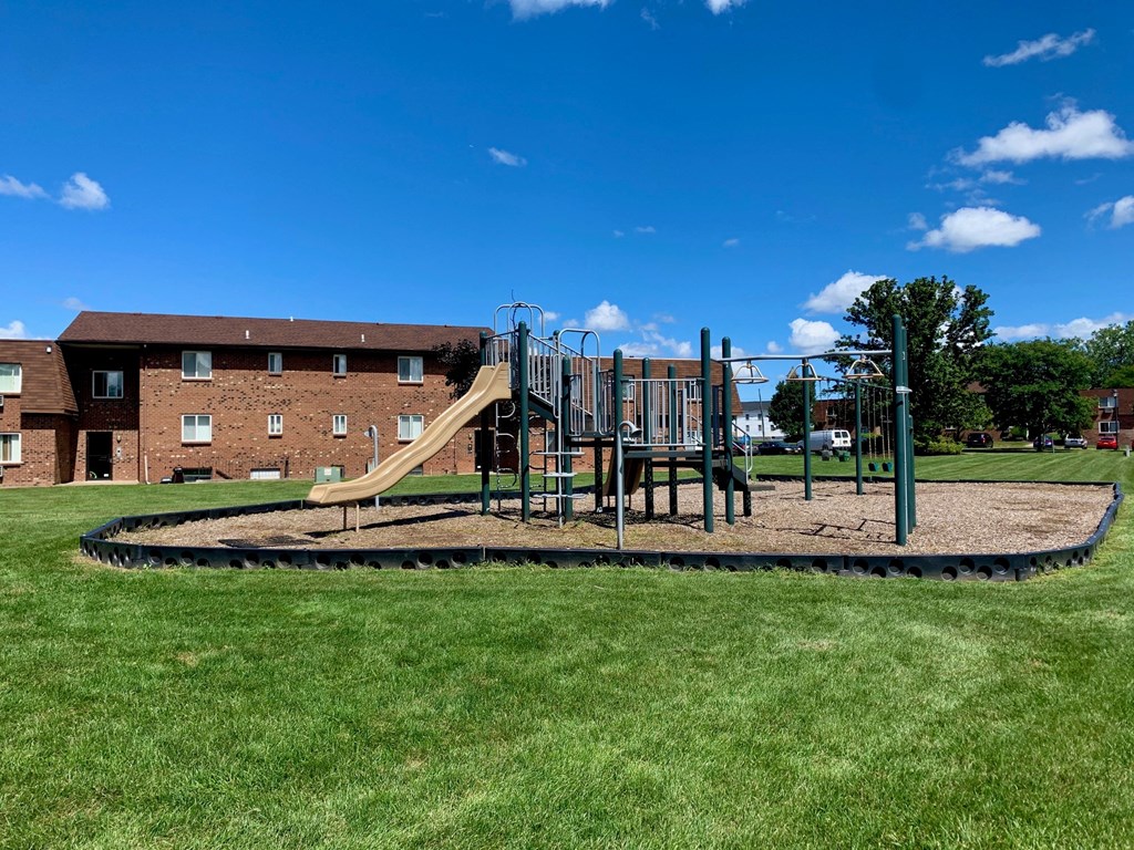 a playground in a park with a building in the background