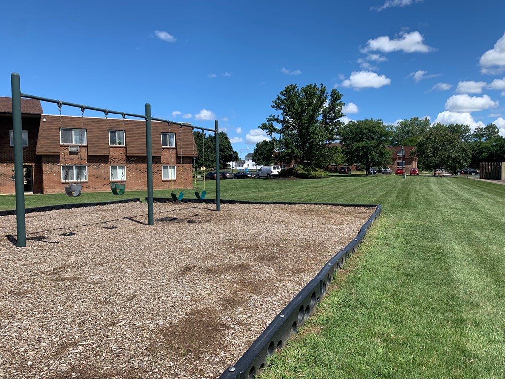 a fenced in dog park in front of a brick building