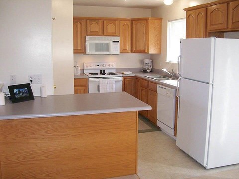 a kitchen with white appliances and wooden cabinets