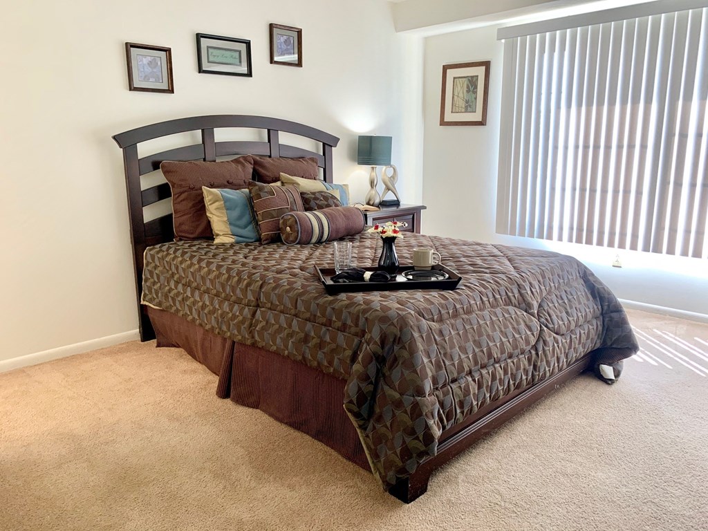 a bedroom with a bed and a window with blinds