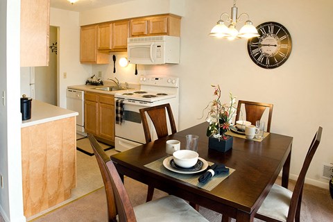 a kitchen and dining table with a clock on the wall