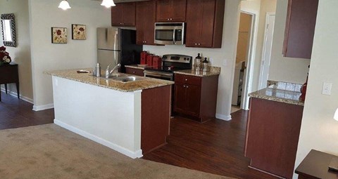 a kitchen with an island and a stove and a refrigerator