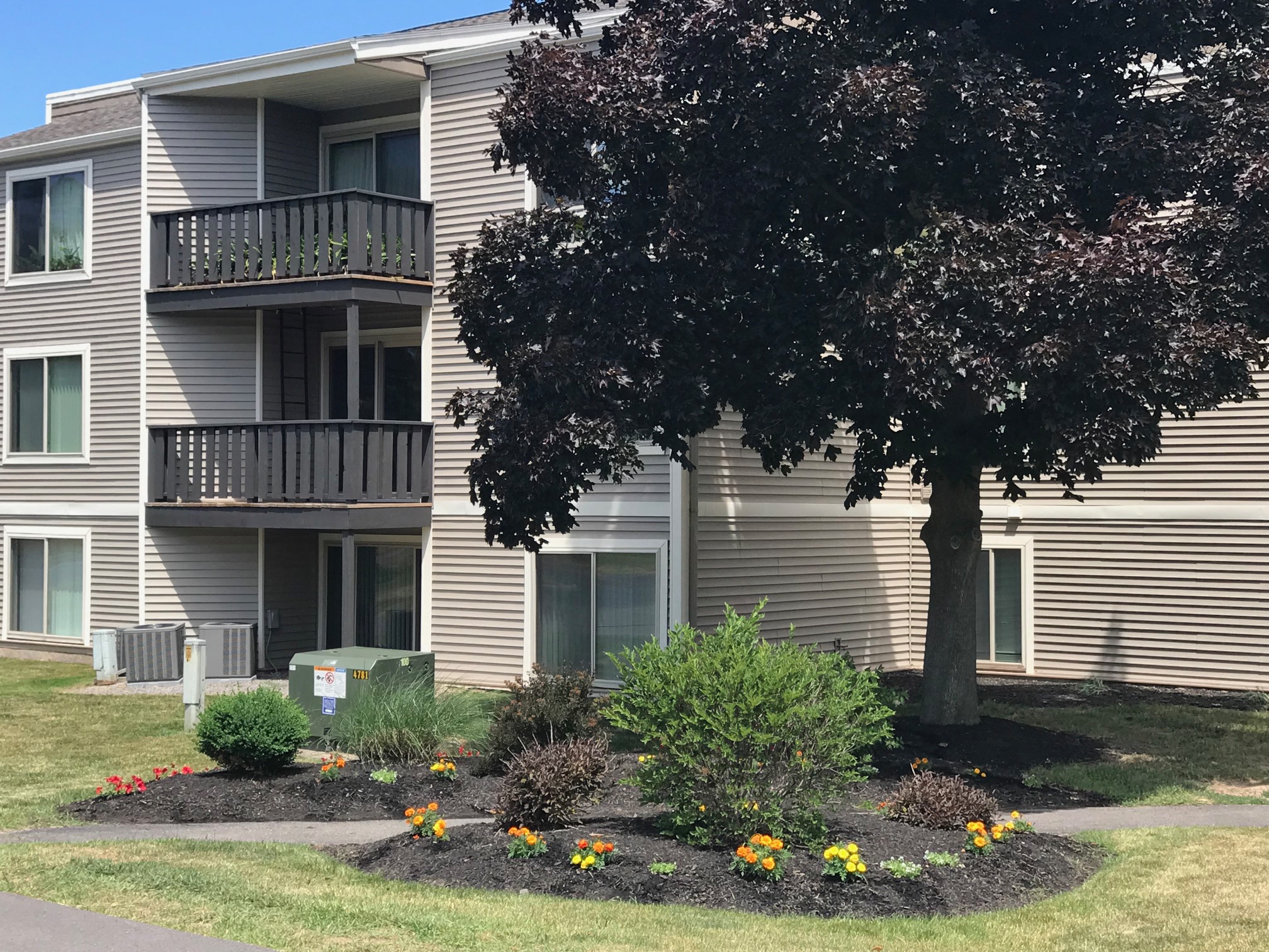 View of Property with Flowers at Whitney Ridge Apartments, Rochester, NY