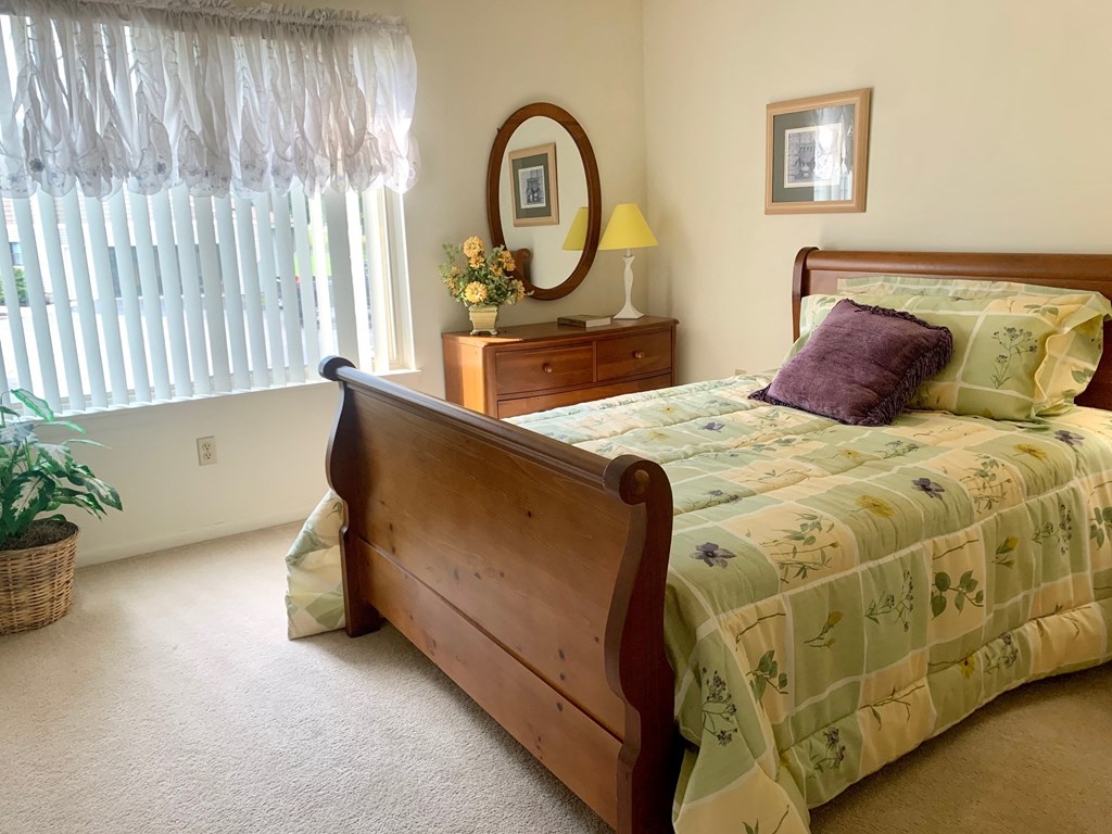 a bedroom with a bed and a dresser and a window
