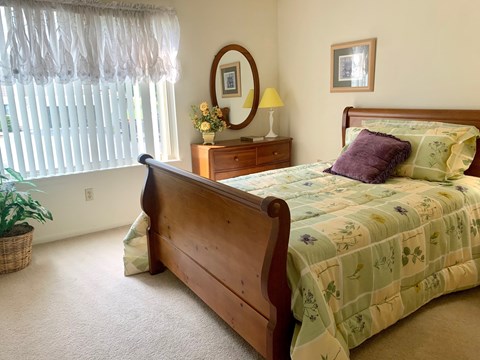 a bedroom with a bed and a dresser and a window