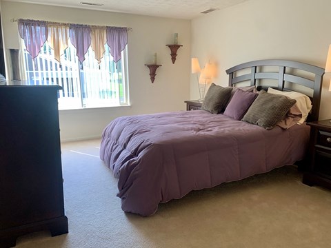 a bedroom with a bed and a window with curtains
