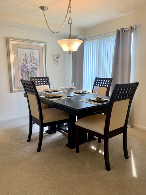 a dining room with a table and chairs and a window