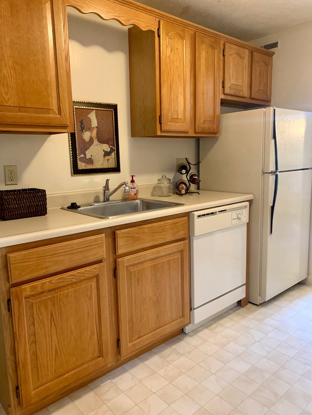a kitchen with white appliances and wooden cabinets