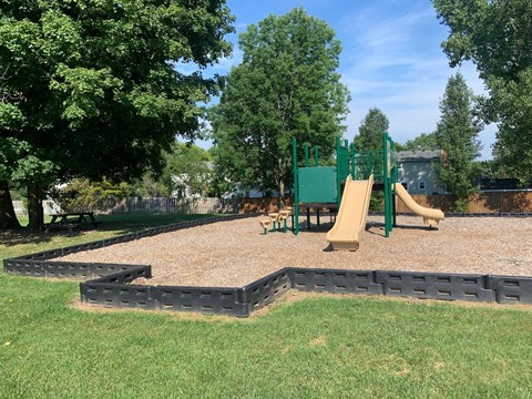 a playground with a swing set and a sandbox