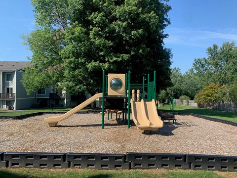 a playground with a slide and other playground equipment in a park