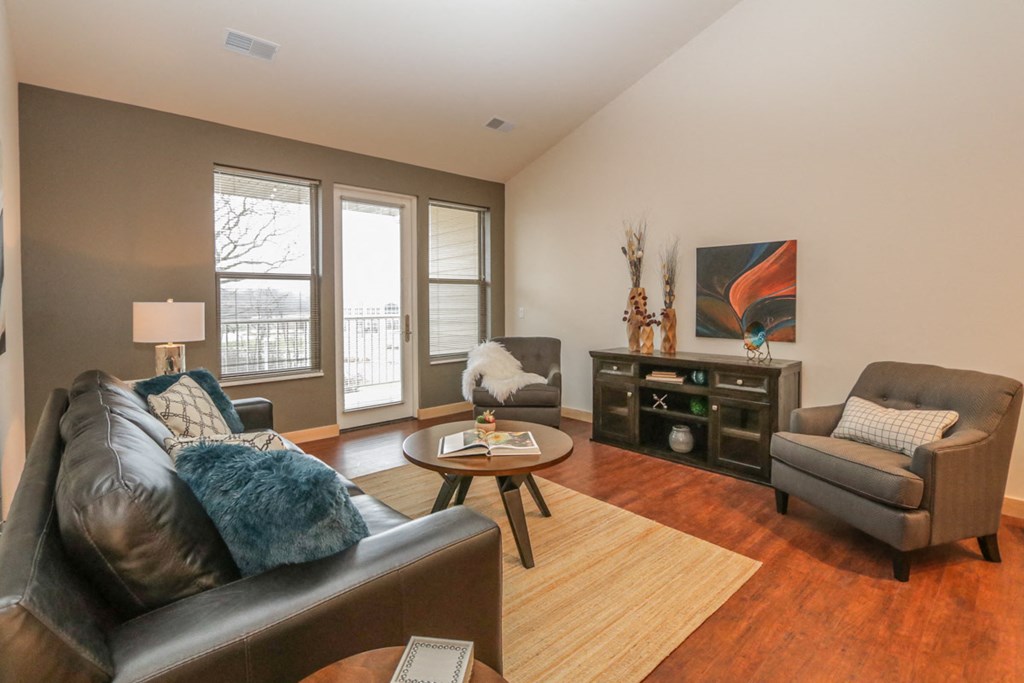 a living room with a leather couch and a chair