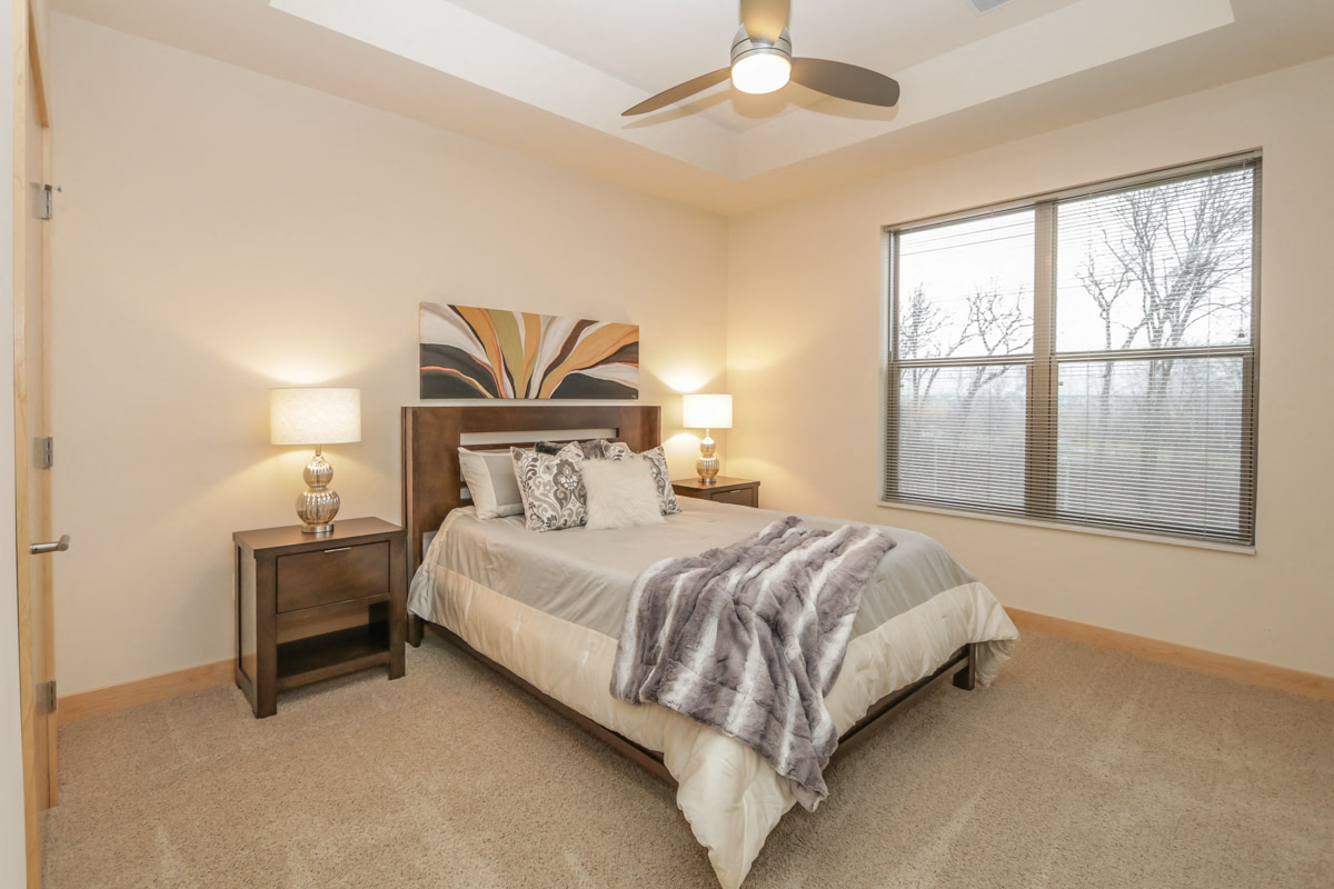 a bedroom with a bed and a ceiling fan