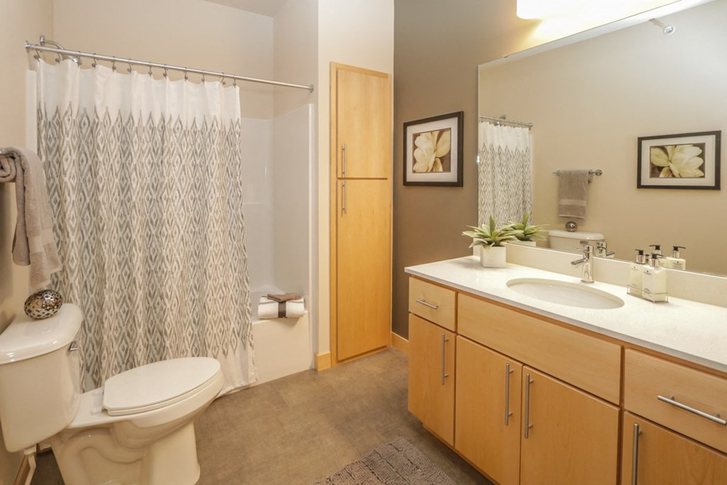 a bathroom with a toilet and a sink and a shower