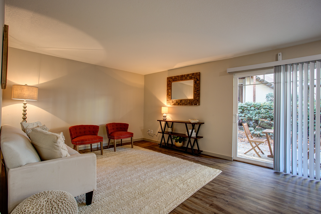 a living room with a couch and chairs and a sliding glass door