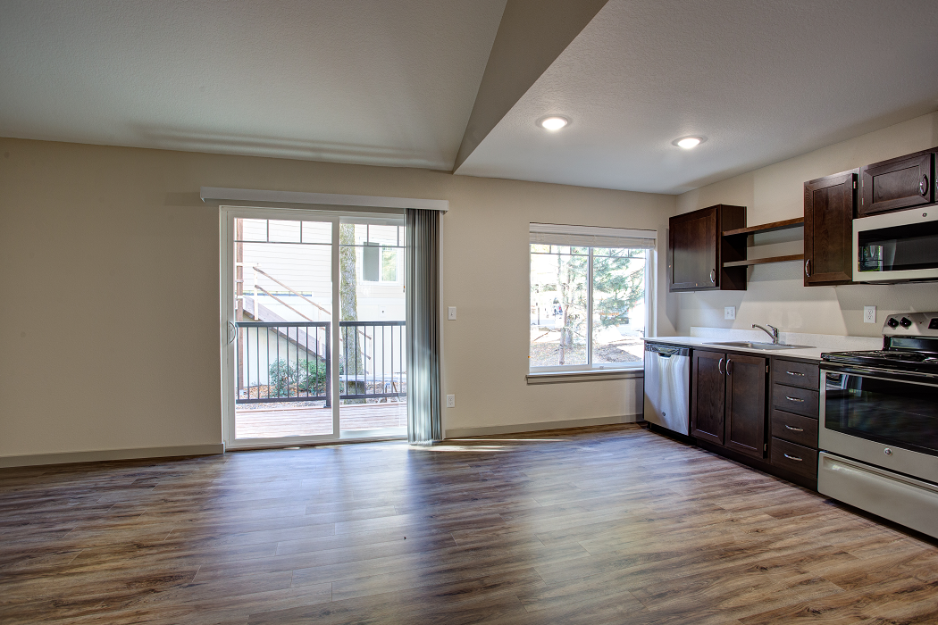 an empty kitchen with a door to a balcony