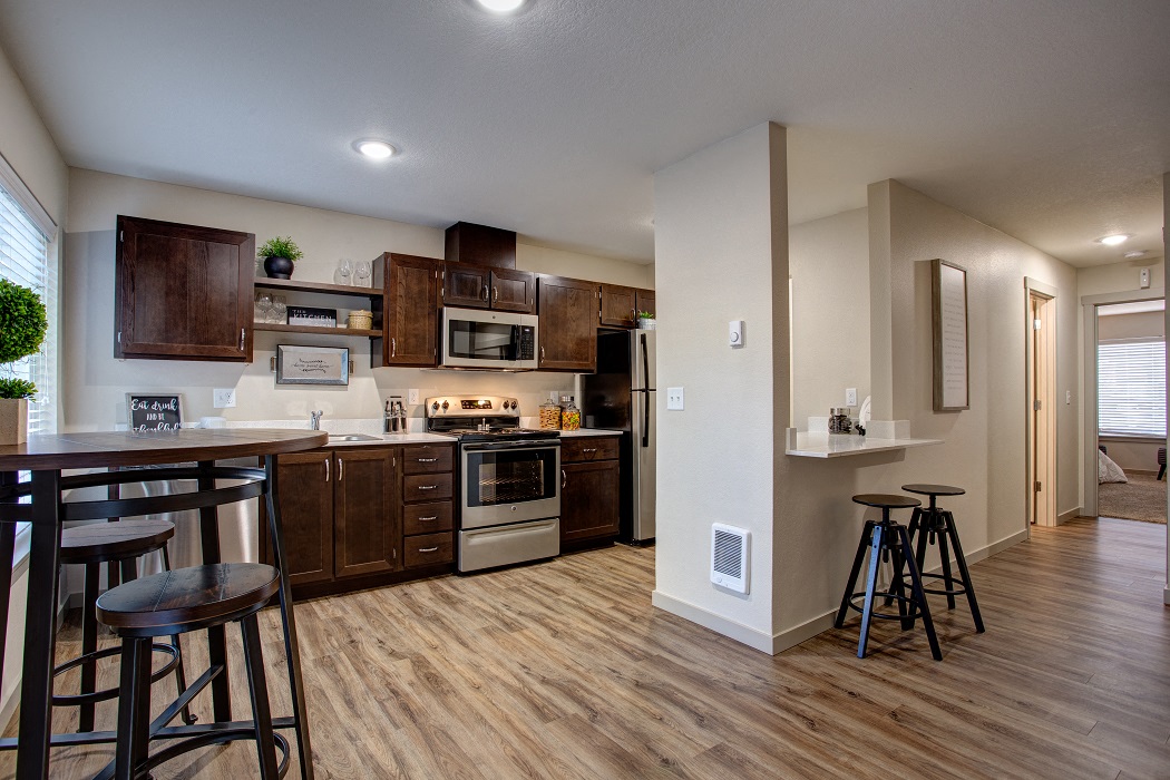an open kitchen with a bar and stools in front of a dining room table