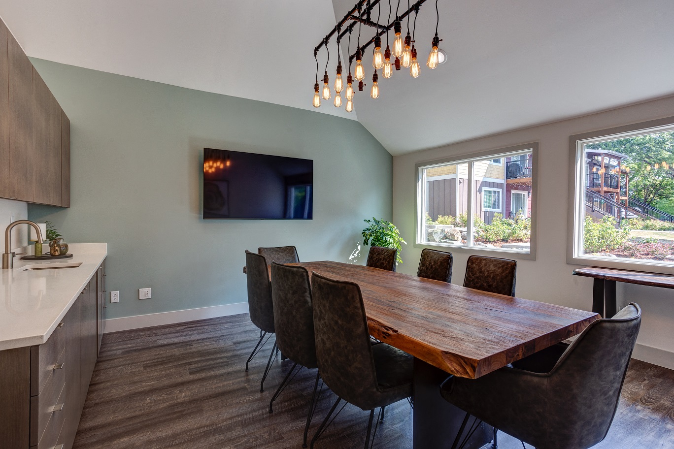 a dining room with a wooden table and chairs and a tv