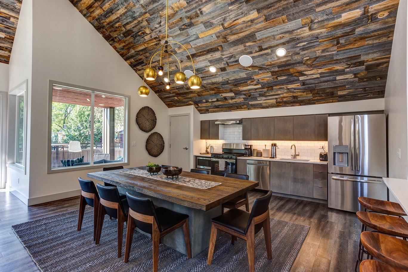 a kitchen with stainless steel appliances and a wooden table and chairs