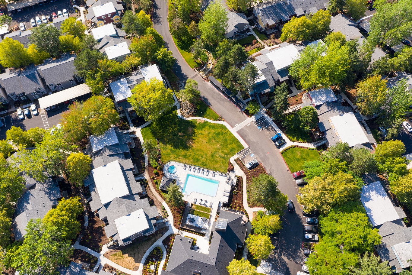 arial view of a neighborhood with houses and a swimming pool