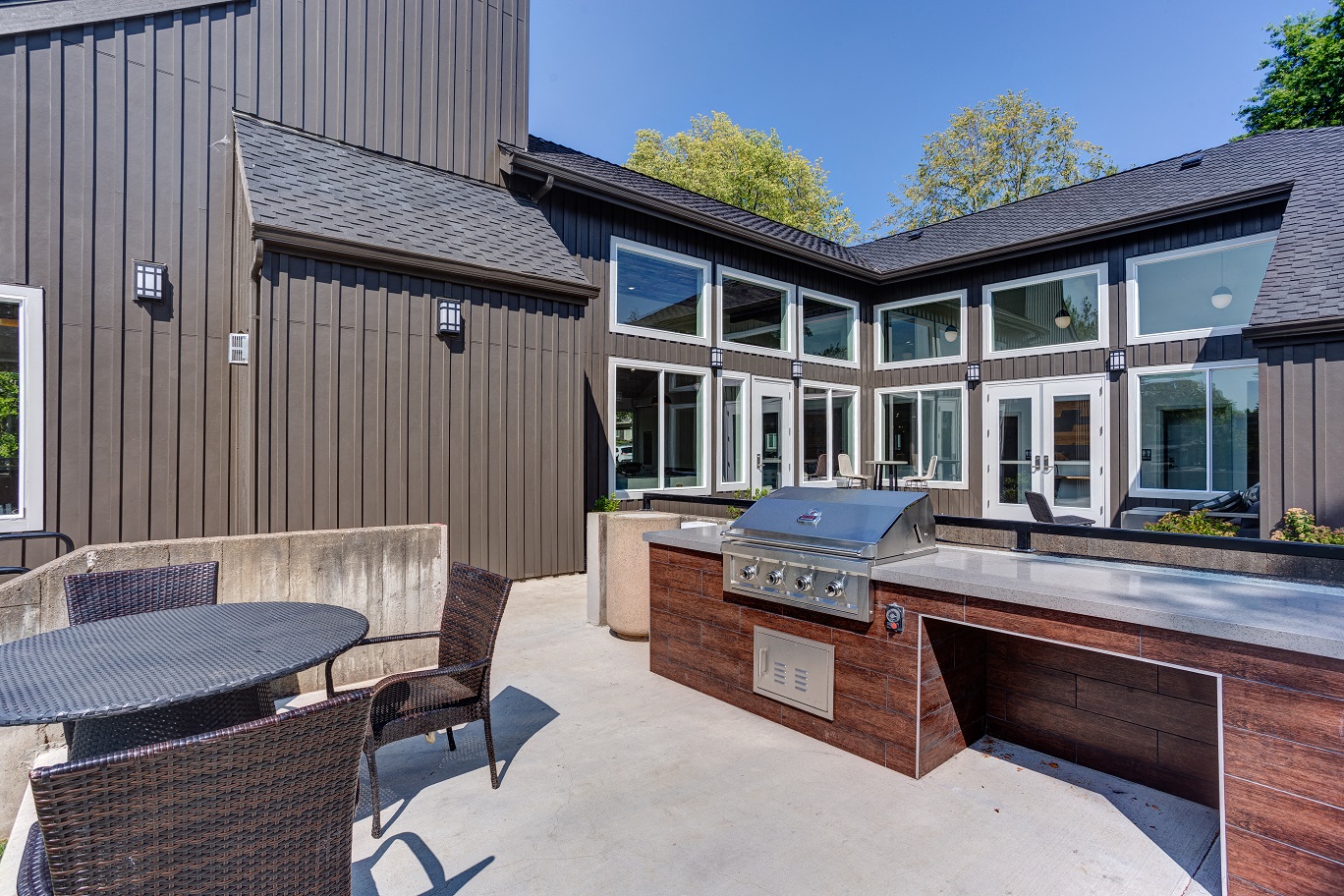 a large patio with a grill and a table and chairs