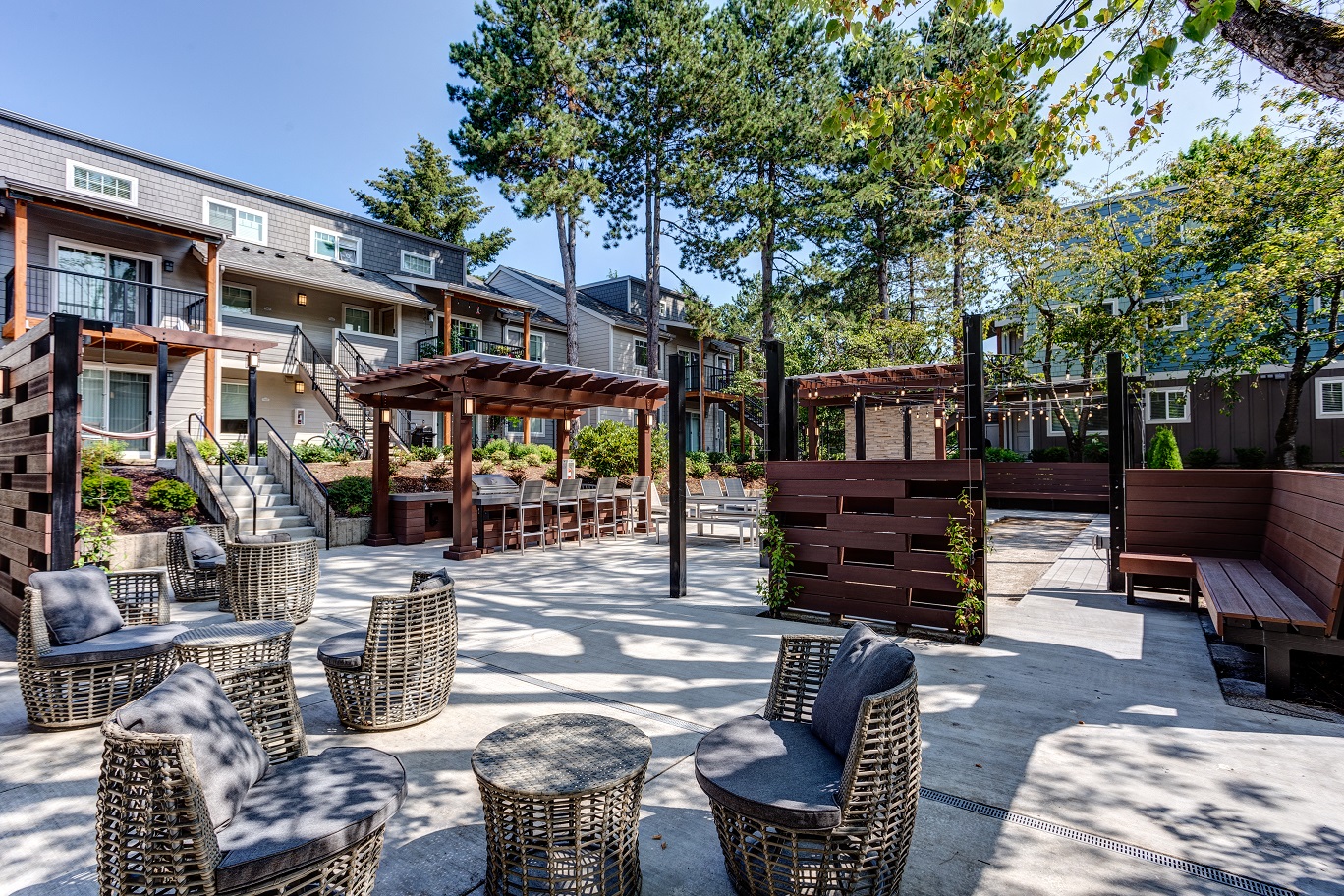 a patio with chairs and tables and trees
