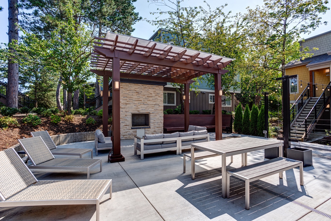 a patio with tables and chairs and a wooden pavilion