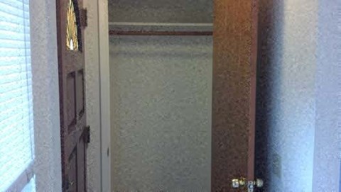 A brown door with a brass handle is in a room.