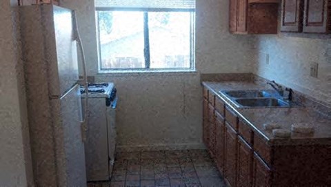 A kitchen with a refrigerator and a sink.