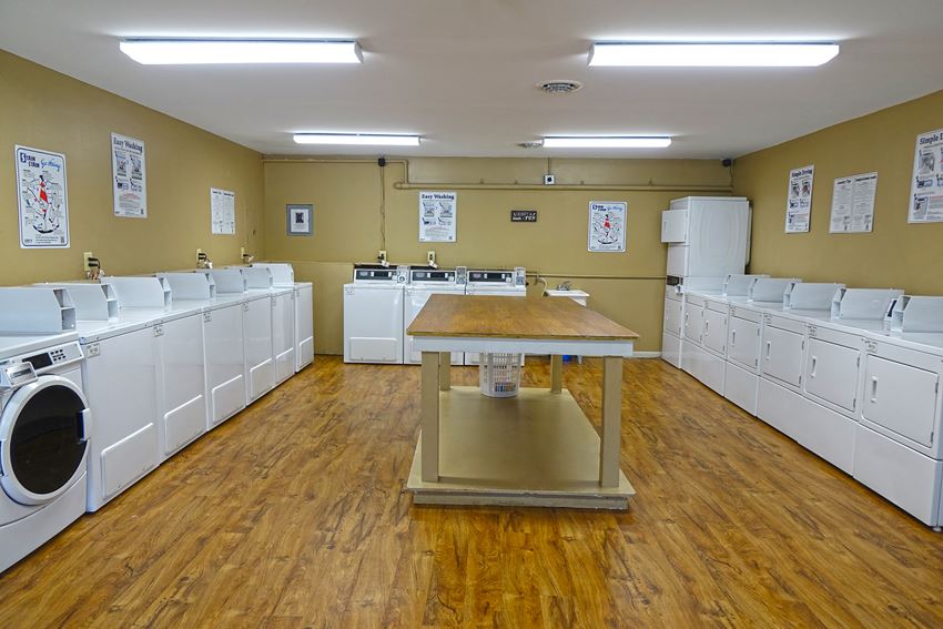 a washer and dryer room with a table in the middle