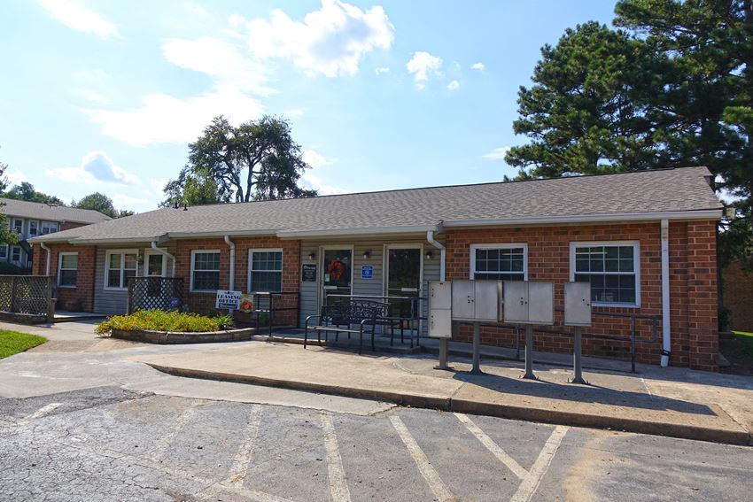 the front of a brick building with a parking lot