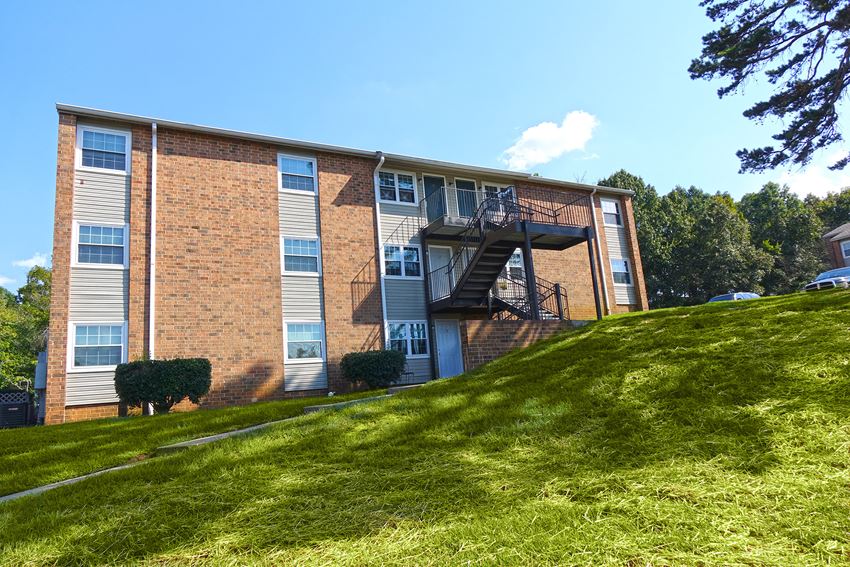 a brick apartment building on a hill with a staircase