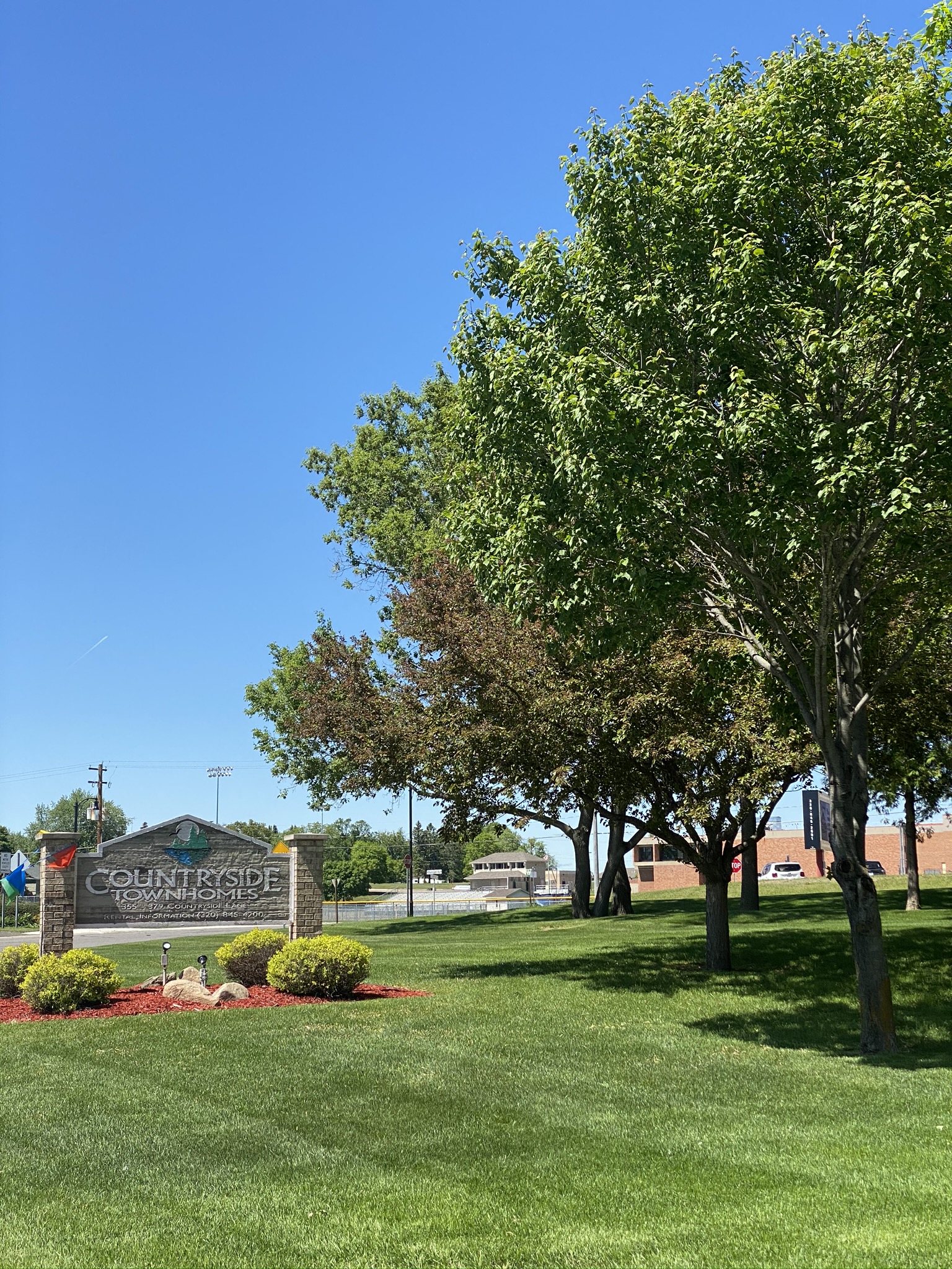 A sign that says Countryside in front of some trees.