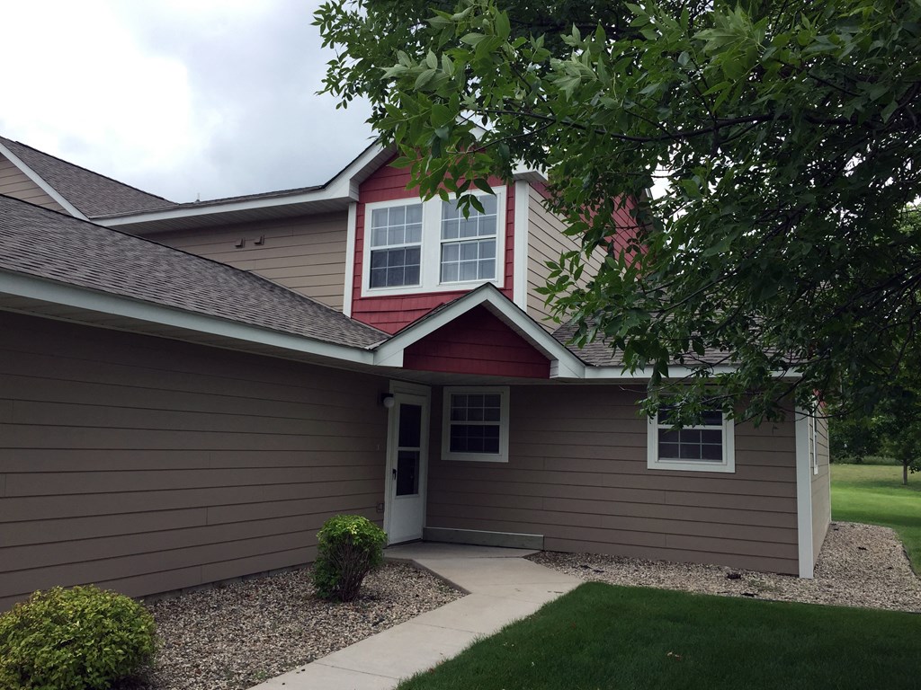A house with a red roof and a brown siding.