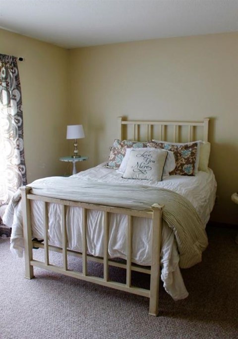 a bedroom with a white bed and a window