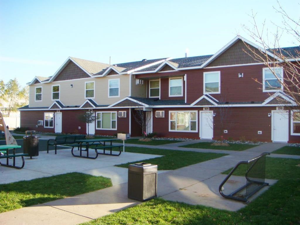 a group of houses with a patio and picnic tables in front of them