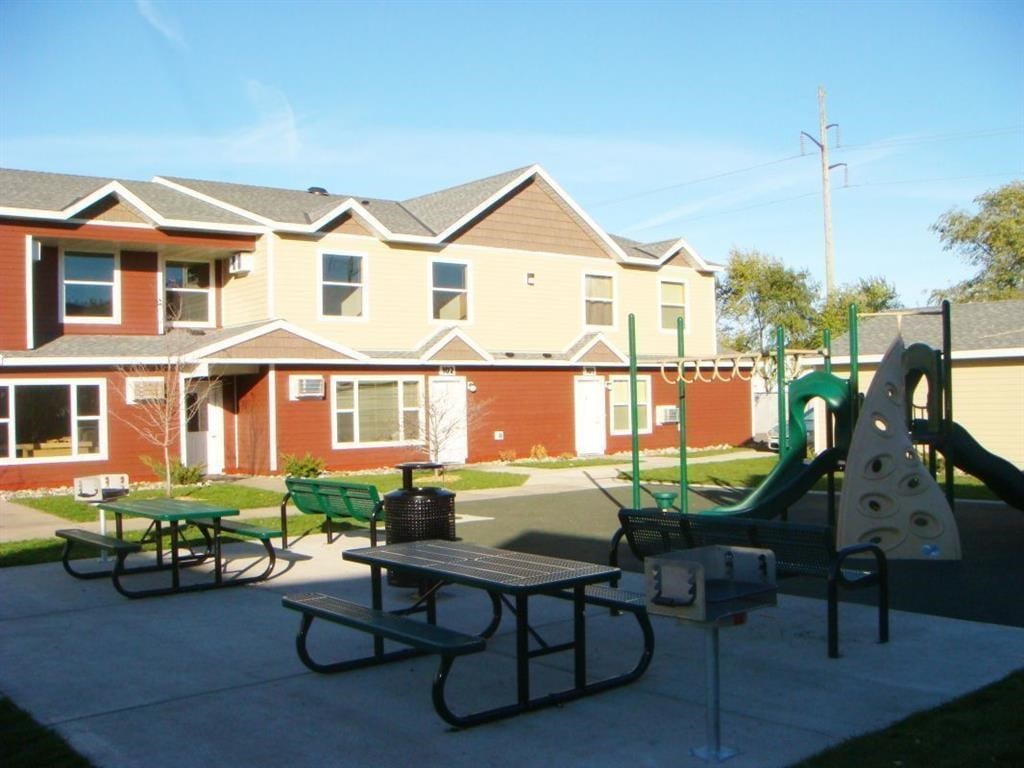 a playground in a park with houses in the background