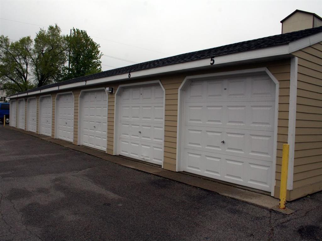 a row of white garage doors on the side of a building