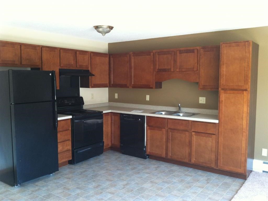 a kitchen with black appliances and wooden cabinets
