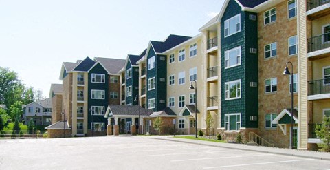 Apartment complex with green and beige buildings.