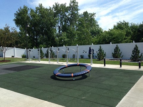 A playground with a blue and orange ring in the middle.