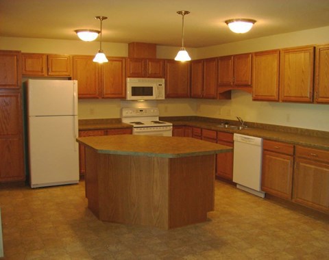 A kitchen with wooden cabinets and a white refrigerator.