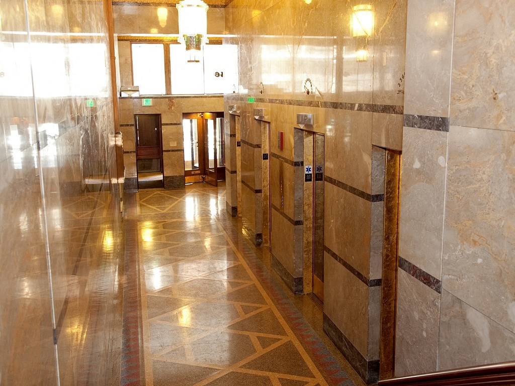 a public restroom with a row of urinals and glass doors