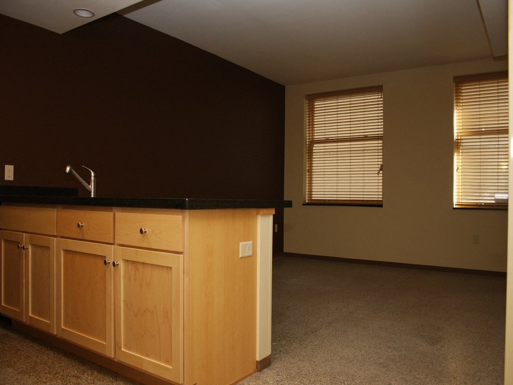 an empty kitchen with wooden cabinets and a sink